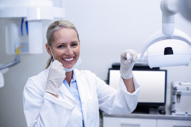 Dentista feminina segurando luzes dentárias