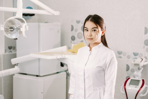 Dentista feminina sorrindo para sua clínica