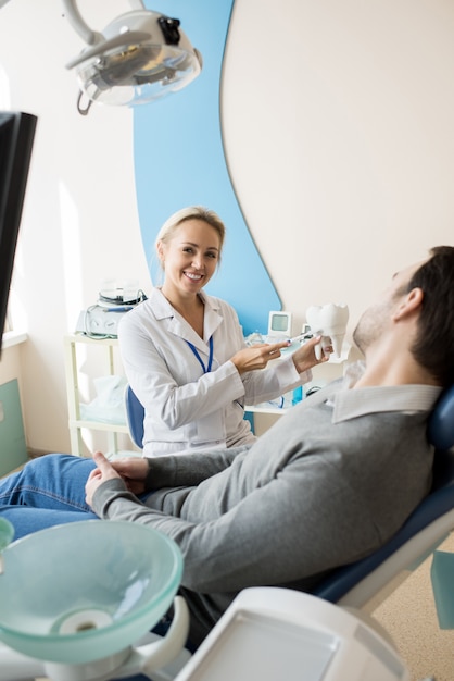 Foto dentista feminina trabalhando na clínica moderna