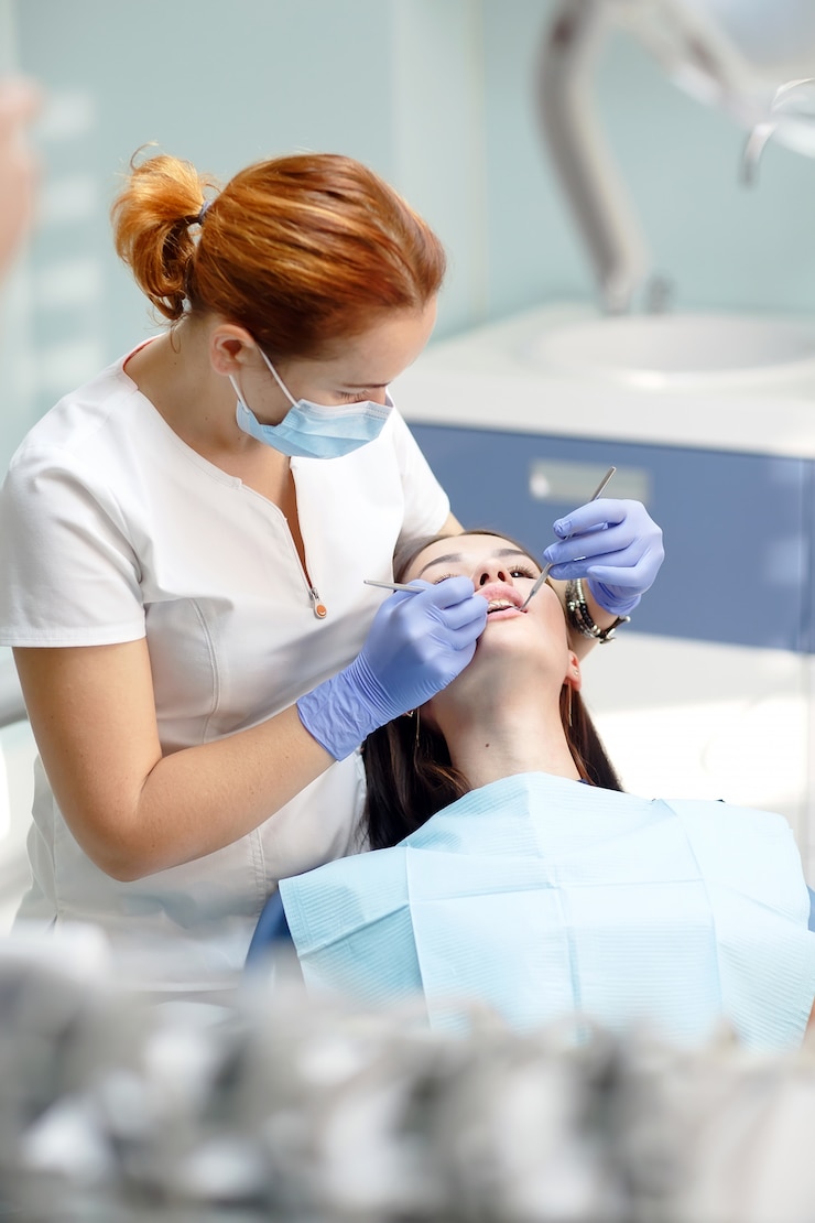 Foto dentista feminina, verificando os dentes do paciente