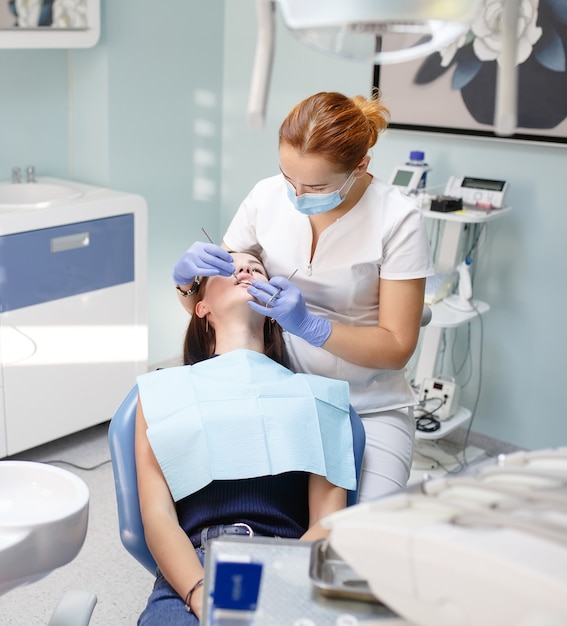 Dentista feminina, verificando os dentes do paciente