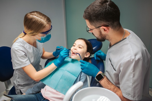 Dentista feminina verificar os dentes da menina