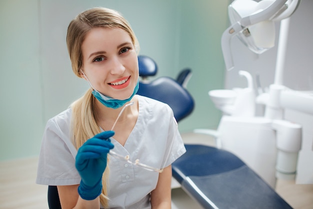 Dentista feminino jovem alegre sentado