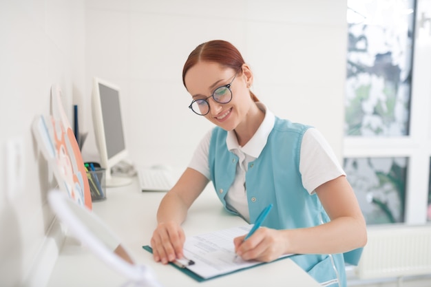 Dentista con gafas. Dentista pelirrojo con gafas y relleno uniforme de alguna forma