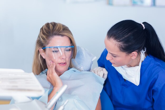 Dentista hablando con un paciente sobre el dolor de muelas