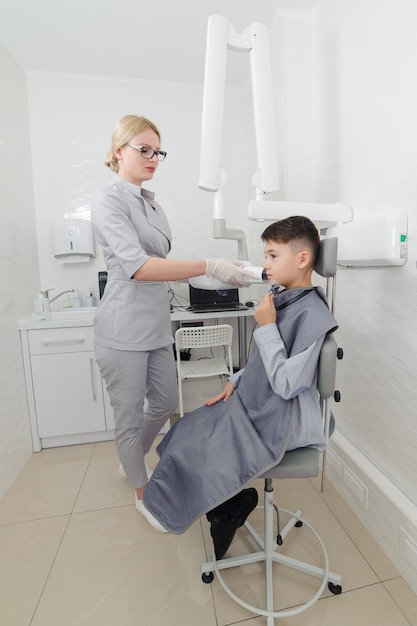 El dentista hace la imagen de rayos x de la mandíbula para el niño en la clínica dental