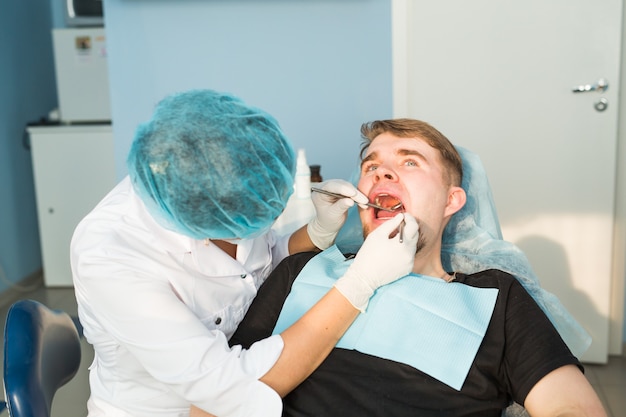 Dentista haciendo un tratamiento dental en un paciente.