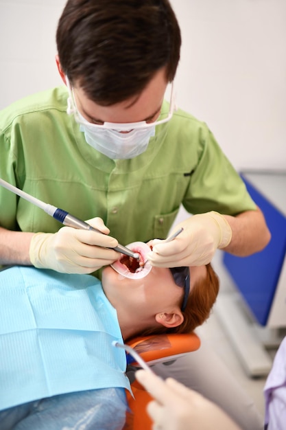 Dentista iniciando operação comum de limpeza da boca feminina