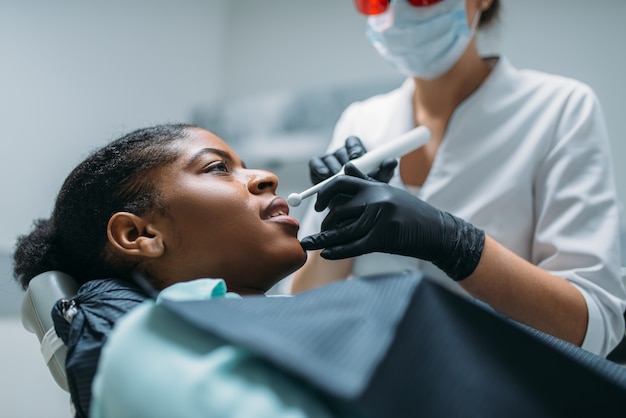 Foto el dentista instala el sello en el diente, clínica dental