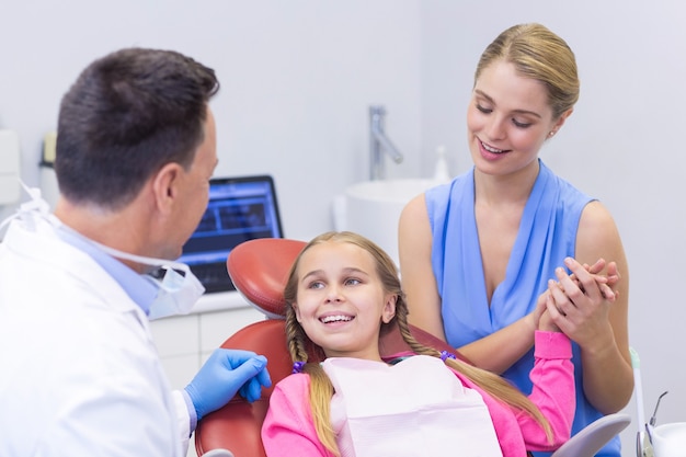 Dentista interagindo com jovem paciente