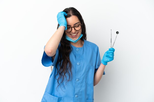 Foto dentista jovem segurando ferramentas isoladas no fundo branco rindo