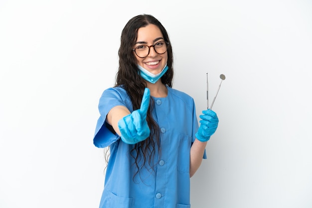 Foto dentista jovem segurando ferramentas isoladas