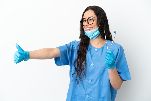 Dentista joven sosteniendo herramientas aisladas