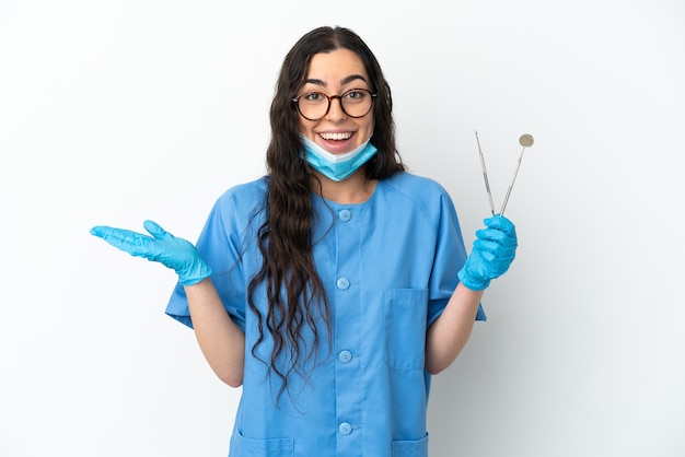 Foto dentista joven sosteniendo herramientas aisladas