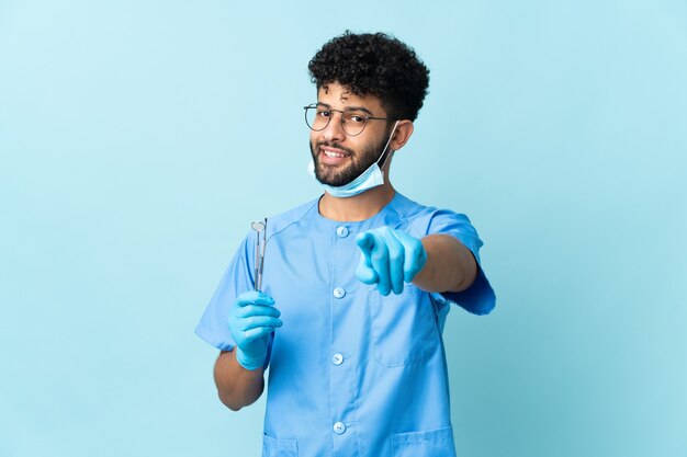 Dentista marroquí hombre sujetando herramientas aisladas