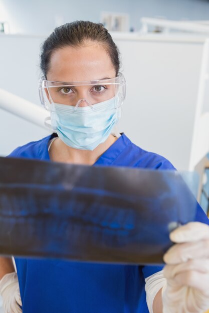 Foto dentista con máscara quirúrgica y gafas de seguridad