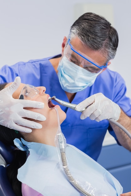 Dentista con máscara quirúrgica y gafas de seguridad