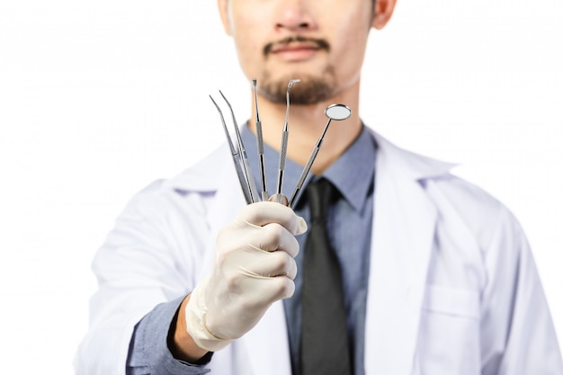 Dentista masculino asiático con herramientas en blanco
