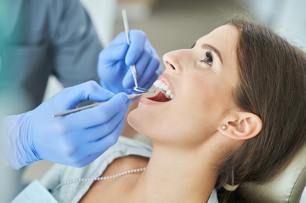 Dentista masculino e mulher em consultório dentário