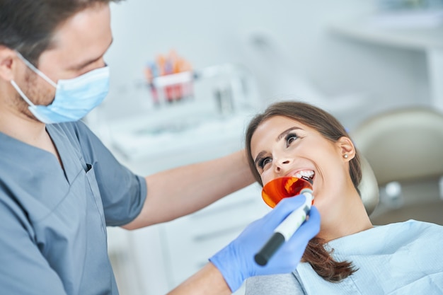 Dentista masculino e mulher em consultório dentário