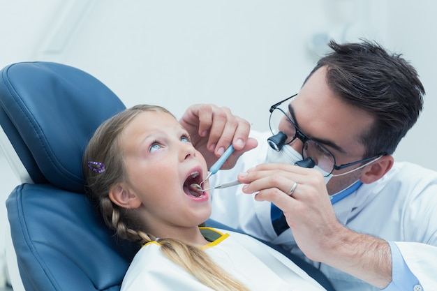 Dentista masculino examinando dentes das meninas