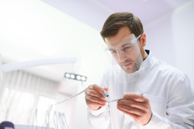 Dentista masculino jovem na clínica