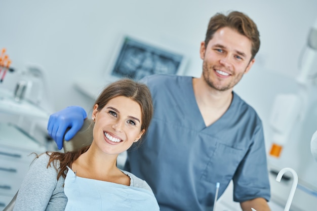 Foto dentista masculino y mujer en el consultorio del dentista