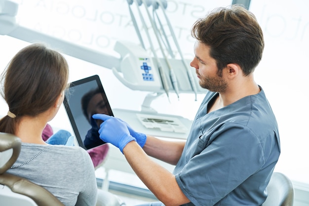 Dentista masculino y mujer en el consultorio del dentista