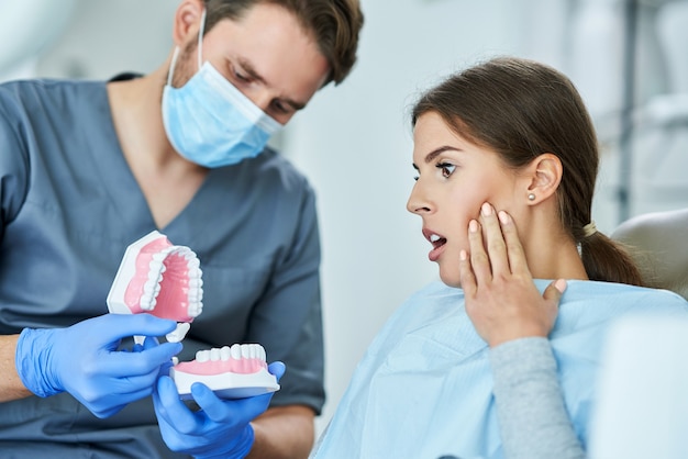 Dentista masculino y mujer en el consultorio del dentista