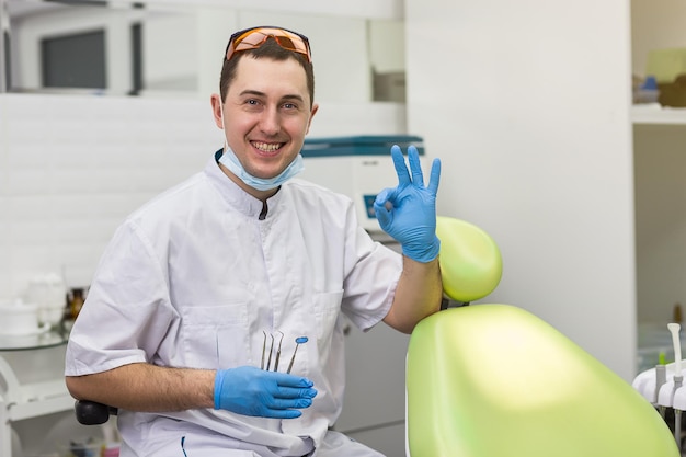 Dentista masculino de pie sobre el fondo de la oficina médica Concepto de estomatología y medicina de la profesión de la salud