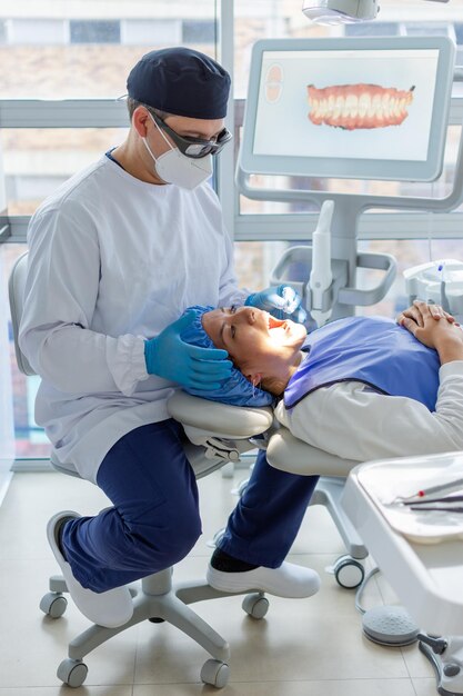Dentista masculino a punto de poner un aparato dental transparente en una paciente