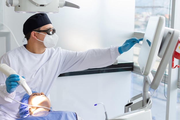 Dentista masculino realizando uma varredura para o modelo 3d da boca de uma paciente feminina Conceito de clínica odontológica