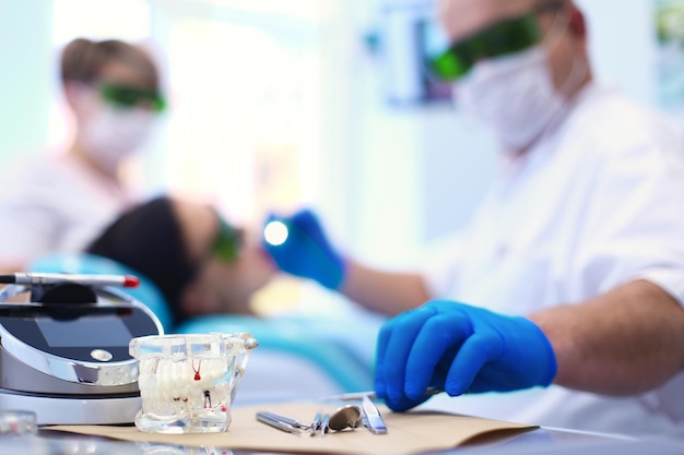 Dentista masculino sênior ajusta o holofote antes de iniciar o trabalho