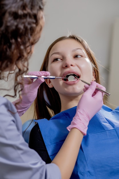 El dentista médico profesional examina y trata los dientes estropeados con el uso de instrumentos dentales especiales