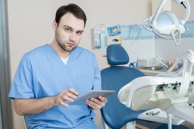 Foto dentista moderno posando no escritório