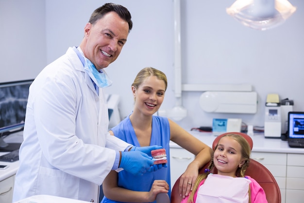 Dentista mostrando ao jovem paciente como escovar os dentes