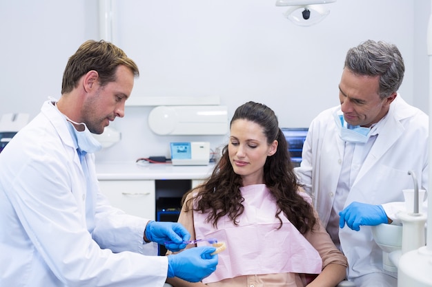 Dentista mostrando dientes modelo al paciente