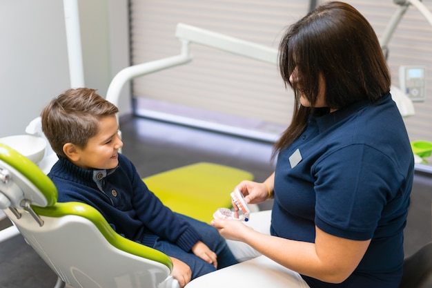 Dentista mostrando modelo de mandíbula para menino