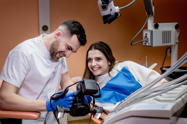 El dentista muestra al paciente una imagen del resultado del tratamiento. Paciente satisfecho