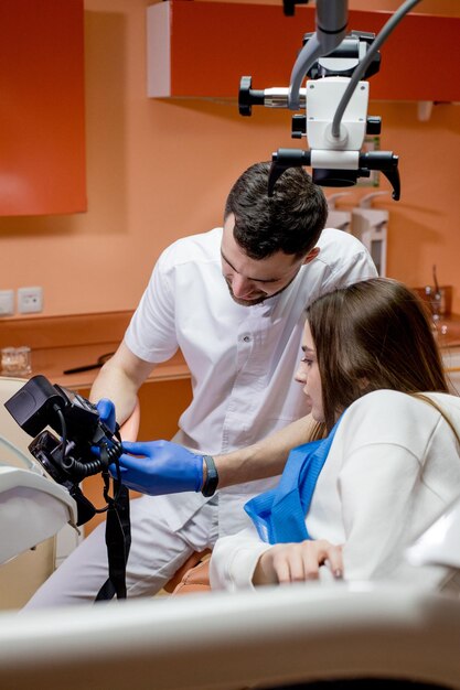 El dentista muestra al paciente una imagen del resultado del tratamiento. Paciente satisfecho