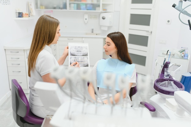 El dentista muestra una radiografía de los dientes del paciente