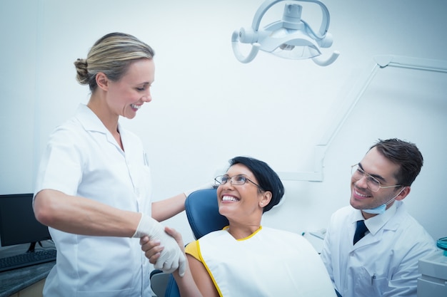 Dentista mujer dándole la mano a la mujer