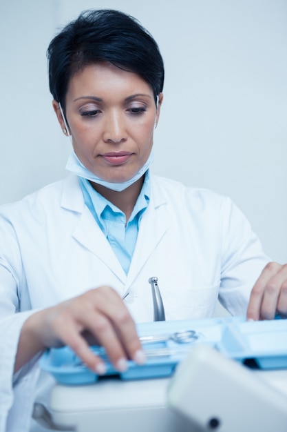 Dentista mujer recogiendo herramientas dentales