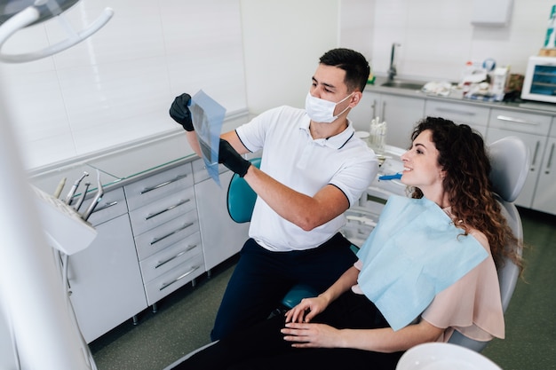 Dentista y paciente mirando radiografía