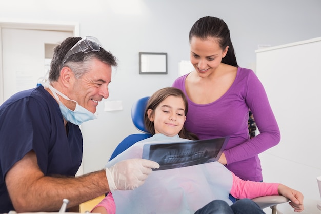 Dentista pediátrica, explicando a mãe e sua filha o raio-x