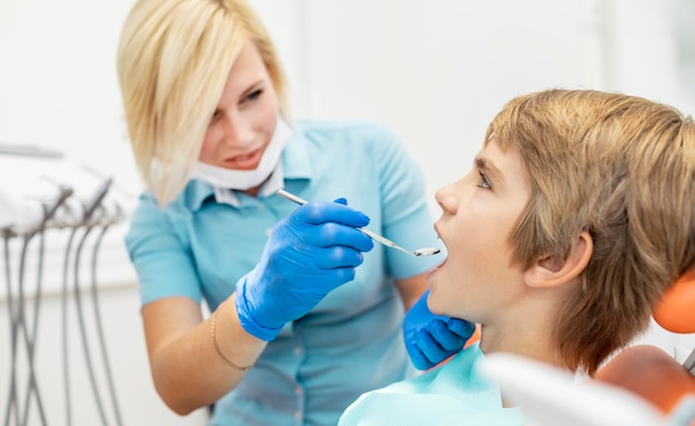 Dentista pediátrico femenino poniendo una boca