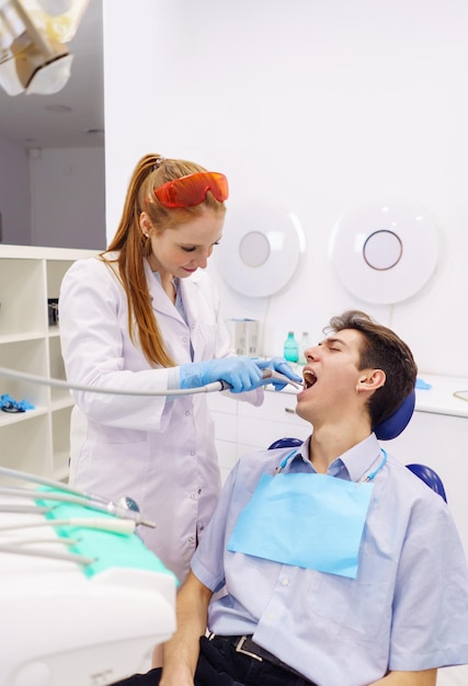 Dentista perforando dientes de hombre