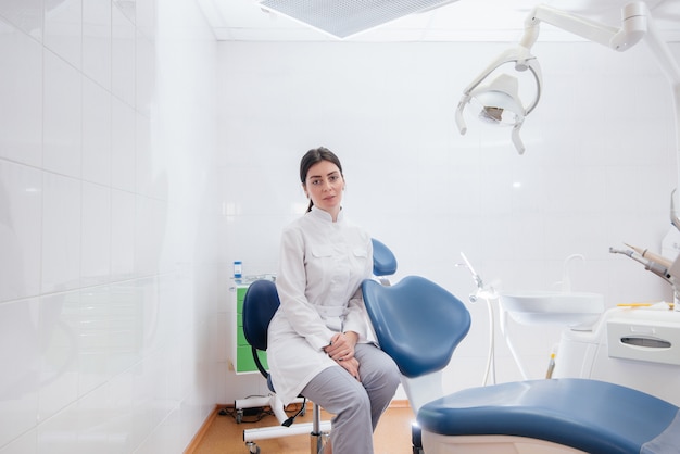 Un dentista profesional se encuentra en un moderno consultorio dental ligero.