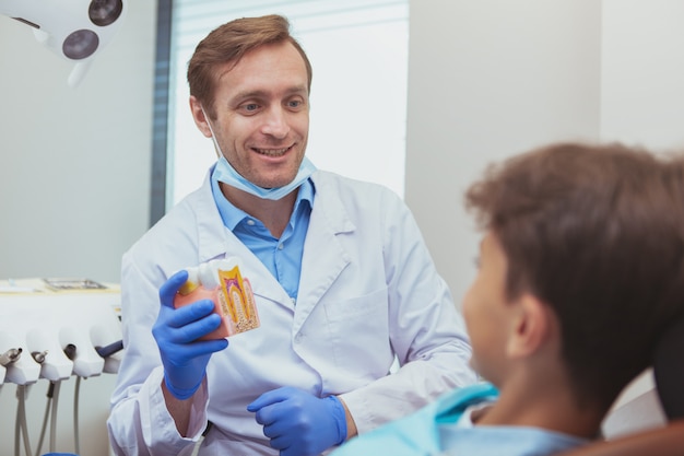 Dentista profissional falando com um garotinho