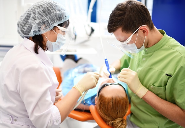 Dentista que comienza la operación común de limpieza de la boca femenina